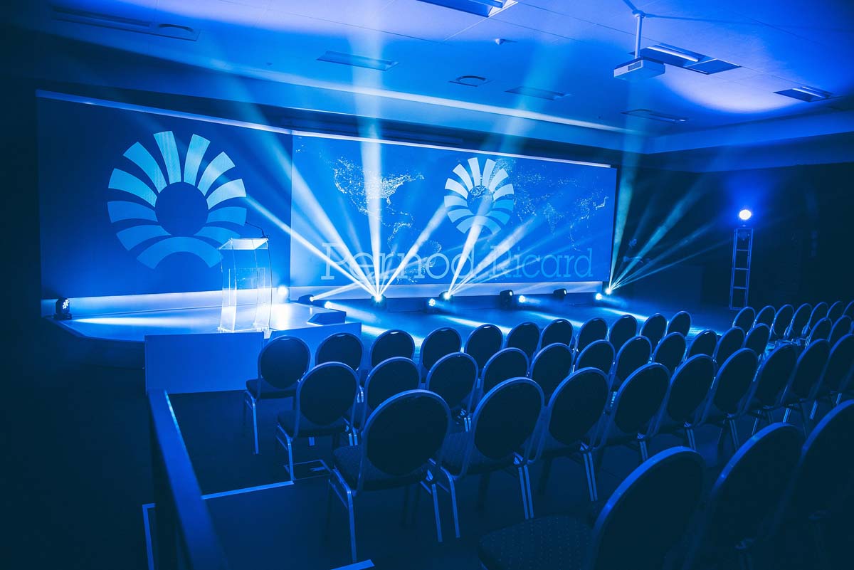 PRSA Business Summit stage with hybrid event cameras, LED screen and seated corporate audience