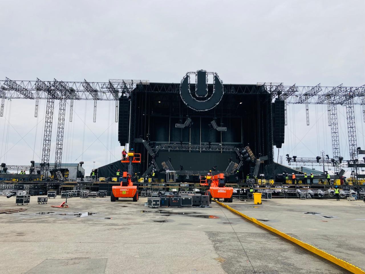 Large-scale festival stage under construction with truss rigging, cherry pickers and crew preparing a major live event production in Africa