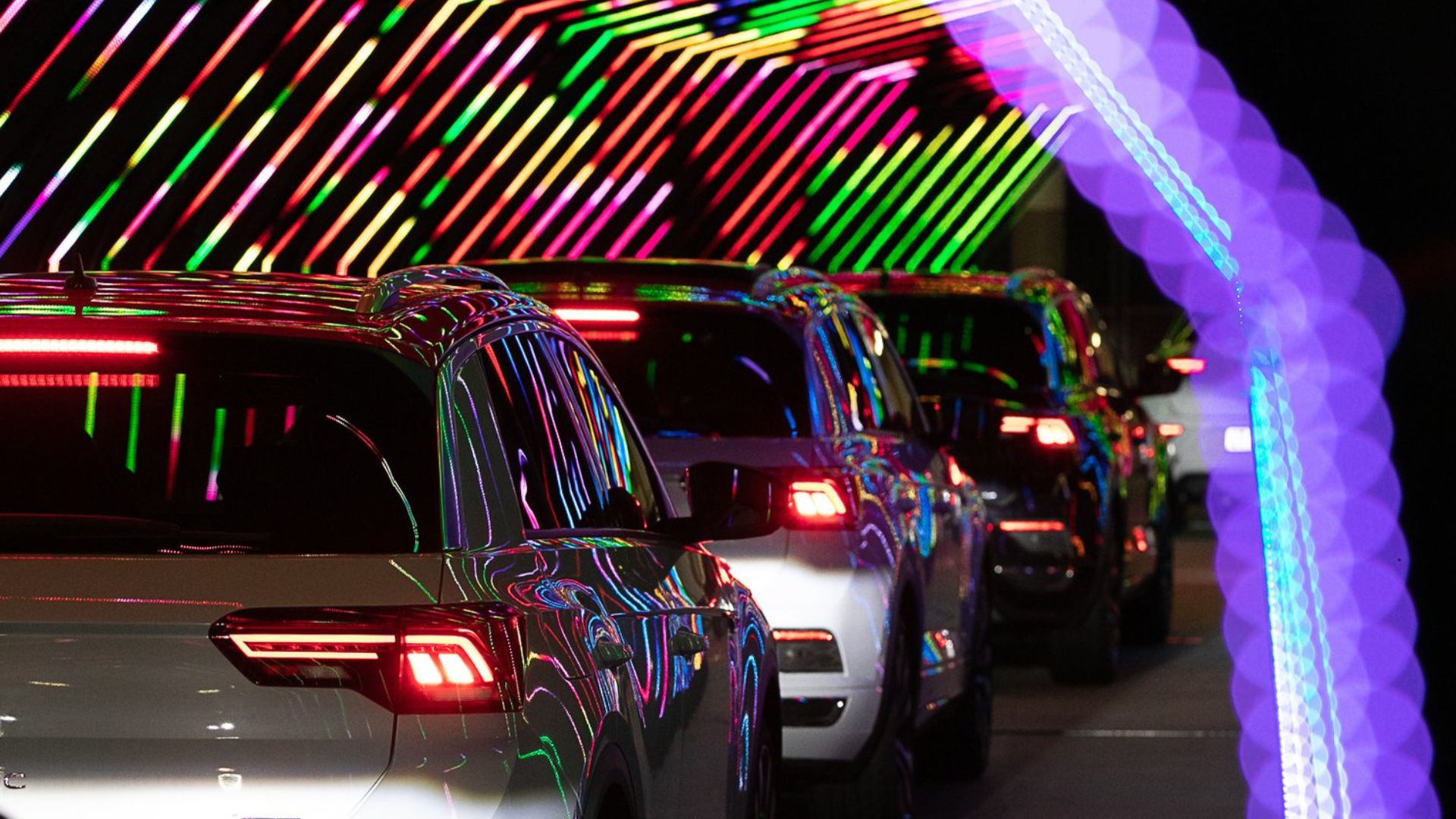 mushroom-motion-brand-launch-filming-automotive-led-reveal-south-africa Mushroom Motion brand launch filming — row of vehicles illuminated by colourful LED light installations at a cinematic automotive product launch in South Africa